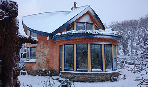 mud and wood house in snow
